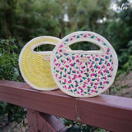 Elaboradas de palma. Forradas de tela, incluye una bolsa con zipper en su interior. Disponibles en diferentes combinaciones de colores (morado, amarillo, rosado, verde, naranja, rojo, azul y natural). Medidas: 24 x 24 x 6.5 cm