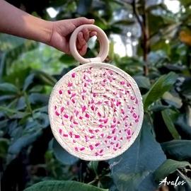 Elaboradas de palma y su agarradero es de madera (10 x 10 cm). Forradas de tela, incluye una bolsa en su interior. Disponibles en diferentes combinaciones de colores (morado, amarillo, rosado, verde, naranja, rojo, azul y natural). Medidas: 24 x 24 x 6.5 cm